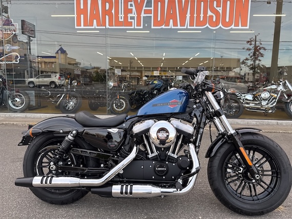 ハーレーダビッドソンの店舗前に展示されたクローム仕上げのクルーザーバイク（ハーレーダビッドソン Fat Boy）